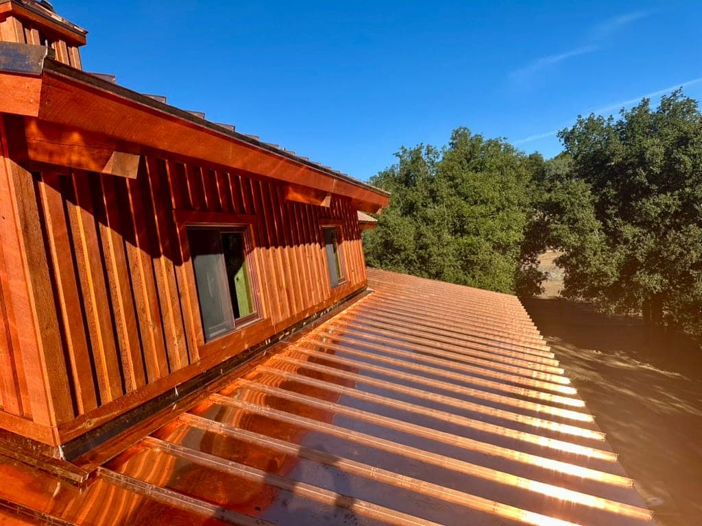 Sunlit copper standing seam roof with dormers